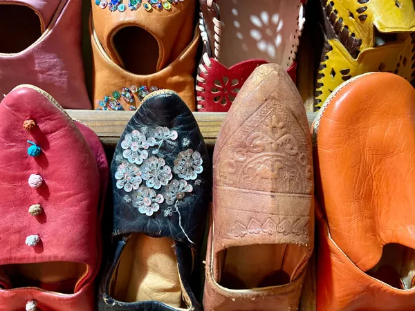 Babouches en cuir rose, orange, naturel, bordeaux et noir, certaines brodées de sequins, sur un étal