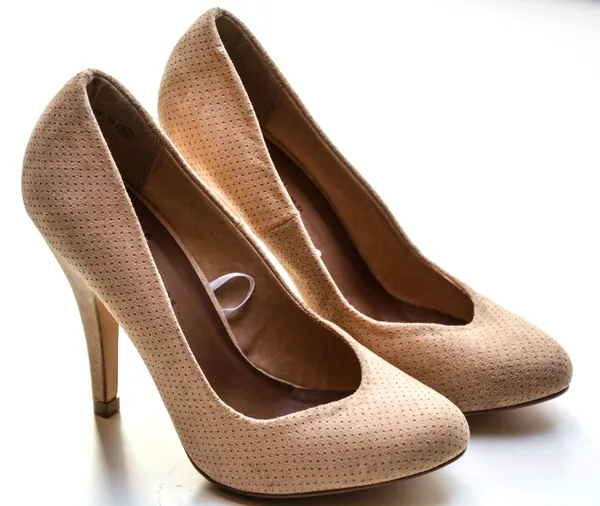 Escarpins beiges à talon haut en cuir micro-perforé sur fond blanc