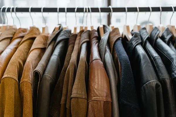 Vestes et blousons en cuir marron, camel et noirs serrés sur un portant